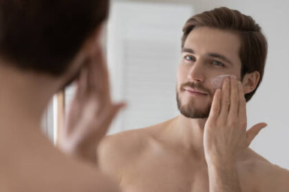 hombre cuidando su piel con mascarillas viendose al espejo